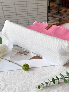 Detail der gewebten Tragetasche in Rosa und Weiß mit braunen Griffen und verstärktem Boden
