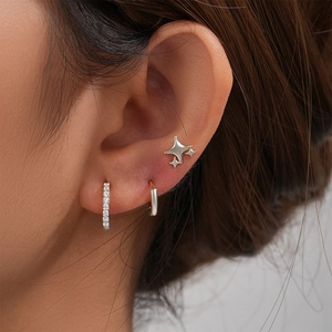 Detailed macro view of 925 silver stud and hoop earring set with zircon accents