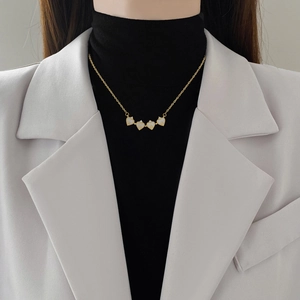 Collier trèfle à quatre feuilles en acier titane porté par un mannequin élégant