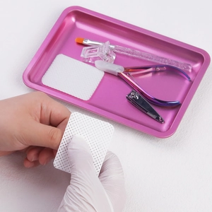 Pink stainless steel tray with manicure tool set and white mesh cotton pads