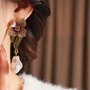 Vue détaillée de boucles d'oreilles fleur vintage avec cristaux et perles baroques