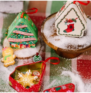 Macro view of Christmas tins in tree and house shapes with festive holiday prints
