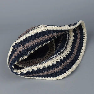 Striped crochet knit bucket hat in navy blue and beige stripes on a neutral background