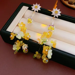Boucles d'oreilles marguerites en cristal avec pompons jaunes et perles ciselées