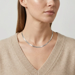 Silver flat snake bone chain necklace worn on model neck for elegant layered jewelry look