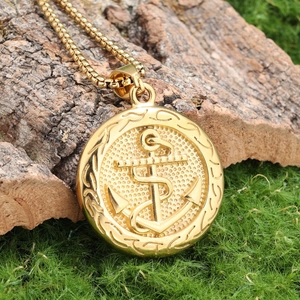 Macro view of golden anchor pendant necklace on natural mossy tree bark background
