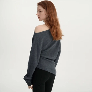 Detail view of the dark grey off-shoulder knit sweater showing its back drape and texture