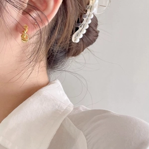 Elegant 925 sterling silver gold twisted knot stud earrings worn by a female model