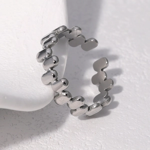 Macro shot of silver adjustable open ring with detailed granular textured metal surface
