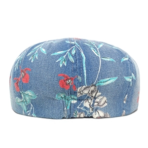 Detailed view of dark blue denim beret with ethnic red floral print and twill texture