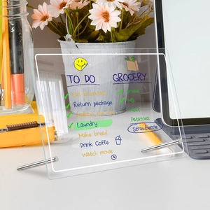 Acrylic dry erase weekly planner board on desk with flowers and tablet setup