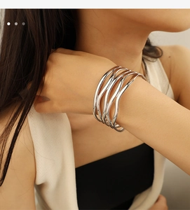 Detail of silver multi-layer wavy open cuff bracelet on a female model wrist