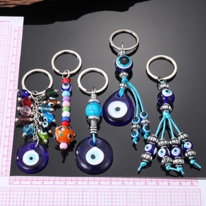 Detail view of five evil eye keychains with vibrant colorful beads and metal pendants
