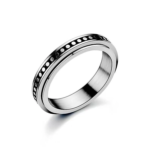 Detail of silver spinner ring with black circle patterns and brushed interior finish