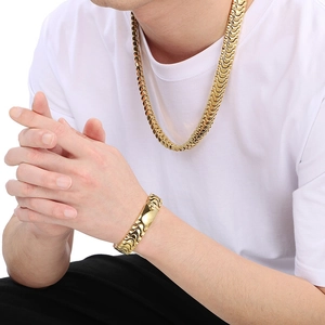 Close-up of a gold polished stainless steel keel chain necklace and bracelet on a model