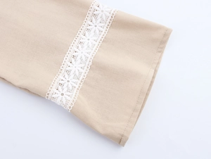 Close-up of beige cotton linen sleeve with white geometric lace embroidery detail