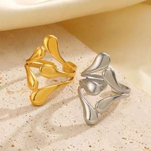 Minimalist adjustable open rings in gold and silver with fluid teardrop design on sand texture