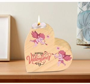 Detail of wooden heart candle holder with Valentine's Day engraving and lit tealight