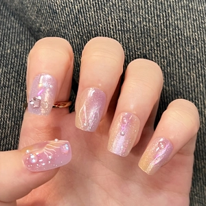 Purple cat eye press-on nails with 3D stars and pearls on denim background