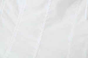 Macro detail of vertical stitching and premium white fabric texture on a long dress