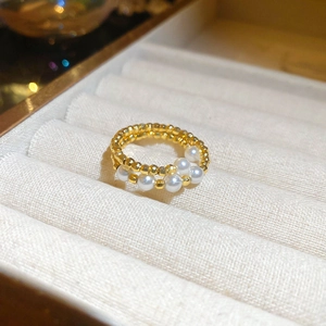 Macro shot of minimalist gold beaded ring with five elegant white pearls in a jewelry box