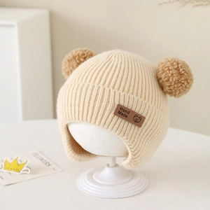 Detail of baby winter knit hat with cute bear ears and a handmade leather patch