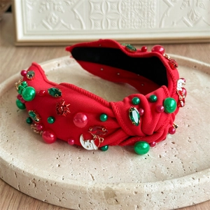 Close-up of red Christmas headband with sparkling rhinestones and pearl embellishments