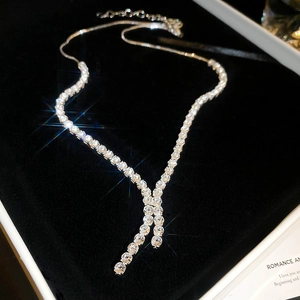 Macro shot of Y-shaped silver necklace with clear cubic zirconia in a black velvet box