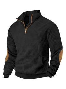 Detail of black quilted sweatshirt with stand collar and brown faux leather trim accents