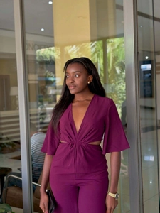 Close-up of deep V-neck and waist cutouts on this elegant purple-red jumpsuit