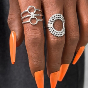 Detail of silver geometric stainless steel rings with textured patterns on model finger