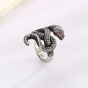 Dettaglio della texture a scaglie di serpente e occhi rossi su anello in acciaio