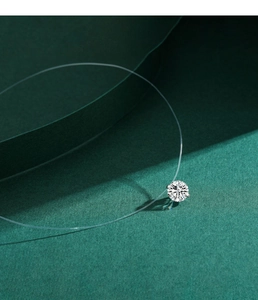 Gros plan du pendentif en zircon brillant sur un collier invisible en fil de nylon clair