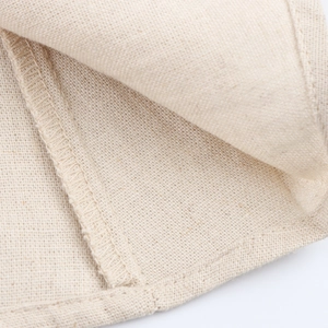 Macro shot of beige linen fabric texture and detailed stitching on the casual dress