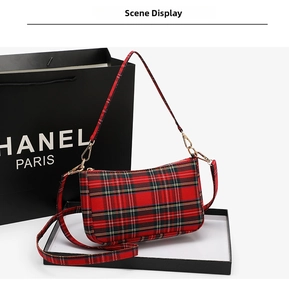 Detail of red tartan baguette bag with gold zipper and detachable dual straps