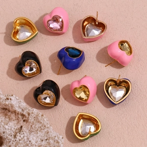 Vue détaillée de boucles d'oreilles en cœur avec centre en cristal et émail coloré