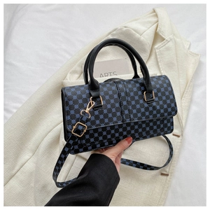 Detail of lychee textured handbag with blue geometric circles and gold hardware