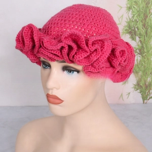 Close-up of crochet knit texture and ruffle brim detail on the rose red winter hat