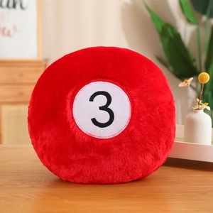 Close-up of red billiard ball No. 3 plush pillow cover on a wooden tabletop
