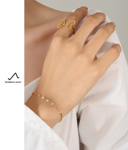 Detail of gold-plated stainless steel hollow butterfly ring and delicate chain bracelet