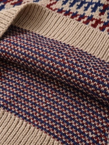 Macro detail of houndstooth knit fabric with red and blue pattern and ribbed texture