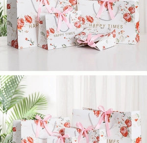 Detail of white marble gift bag with red rose pattern and pink ribbon handles