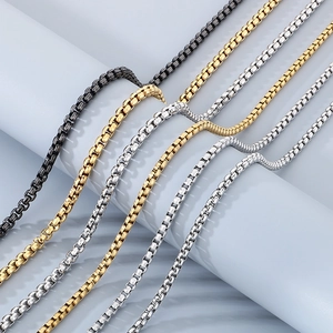 Detail of stainless steel chains in black, gold, and silver draped on a display