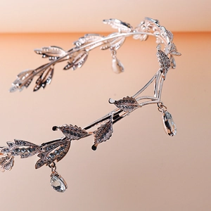 Macro shot of silver bridal crown featuring leaf motifs and teardrop rhinestone accents