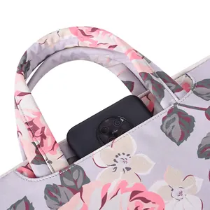 Purple floral laptop sleeve with white rose pattern and front pocket for smartphone storage