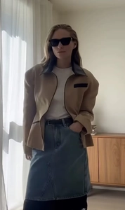 Detailed view of beige cropped jacket with black contrast lapels and structured shoulder design