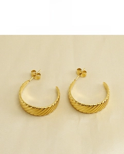 Close-up of 18K gold titanium steel C-shaped earrings with fine spiral texture design