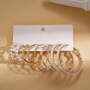 10-piece set of gold hoop earrings with pearls and geometric designs on display card