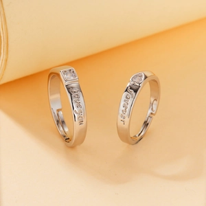 Detail of silver couple rings with Love You and Forever engravings and cubic zirconia