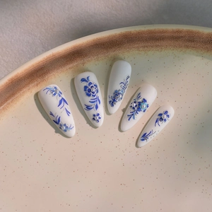 Détail de faux ongles style porcelaine bleue et blanche avec perles en relief 3D
